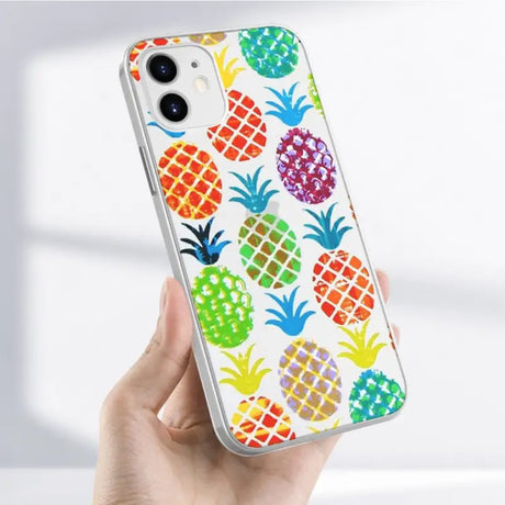 A close up of a person holding a phone case with a pattern of pineapples