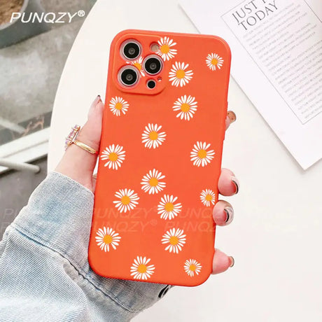 A close up of a person holding a phone case with a flower pattern