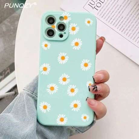 A close up of a person holding a phone case with daisies on it