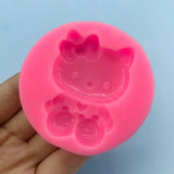 a close up of a person holding a pink hello kitty mold