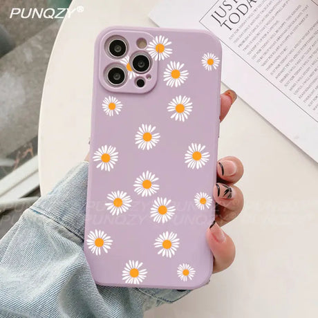 A close up of a person holding a purple phone case with daisies on it