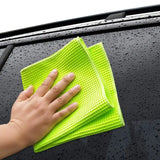 a close up of a person wiping a car with a micro towel