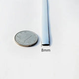 a close up of a quarter of a dime next to a thin tube