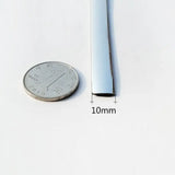 a close up of a quarter of a dime next to a thin metal tube