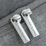 a close up of two metal zippers with a name on them