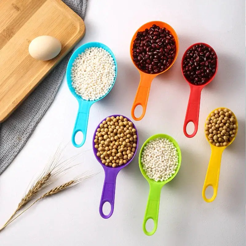 a close up of a variety of measuring spoons with grains and eggs