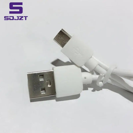 a close up of a white usb cable connected to a white phone