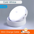 A close up of a white light on a table with a cable