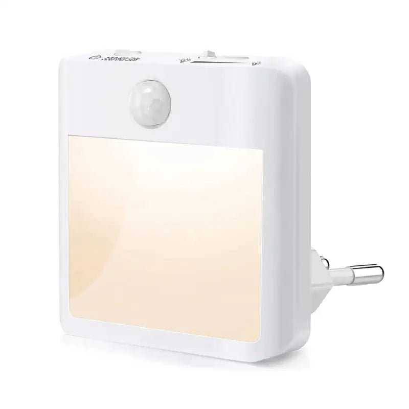 A close up of a white light on a wall with a plug