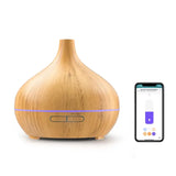 A close up of a wooden diffuser next to a phone