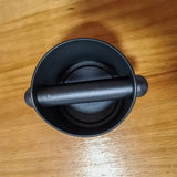 a black knob on a wooden table