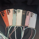 Collection of smartphone cases in various pastel colors with attached lanyards.