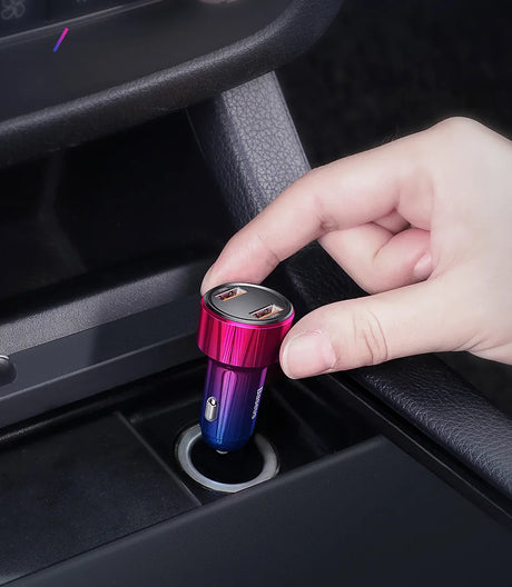 Colorful metallic car USB charger being inserted into a vehicle’s power outlet.