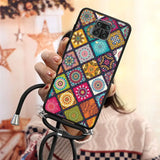 a woman holding a phone case with colorful patterns