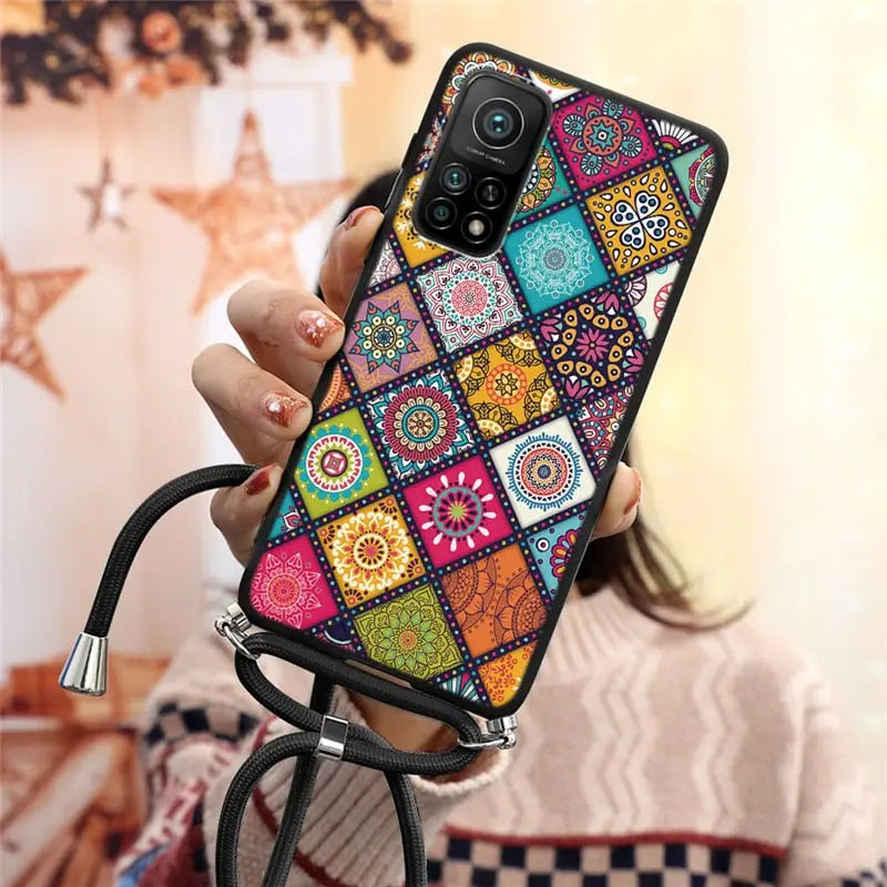 a woman holding a phone case with colorful patterns