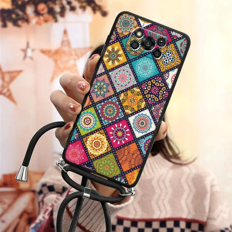 a woman holding a phone case with colorful patterns