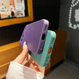 Colorful silicone phone cases in purple and mint green held in a hand.