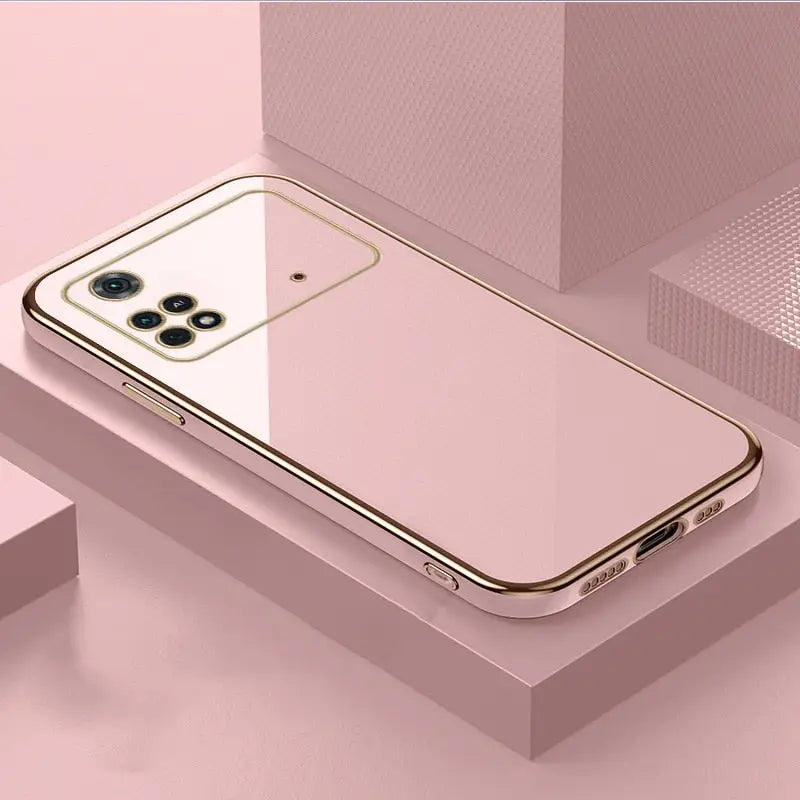 a gold iphone case sitting on top of a pink box