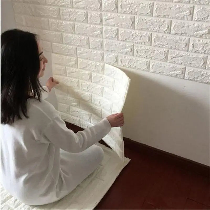 a woman is putting a brick wallpaper