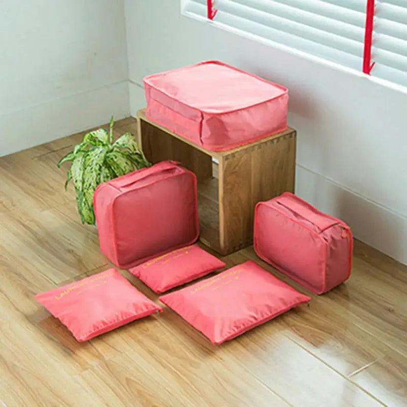 a set of four pink storage bags on a wooden floor