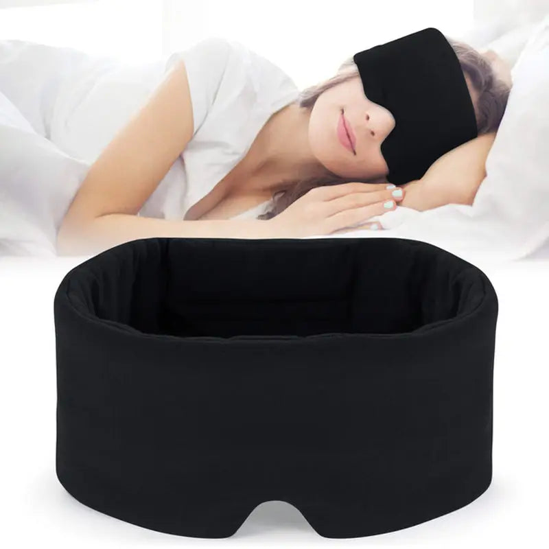 a woman sleeping in bed with a black eye mask