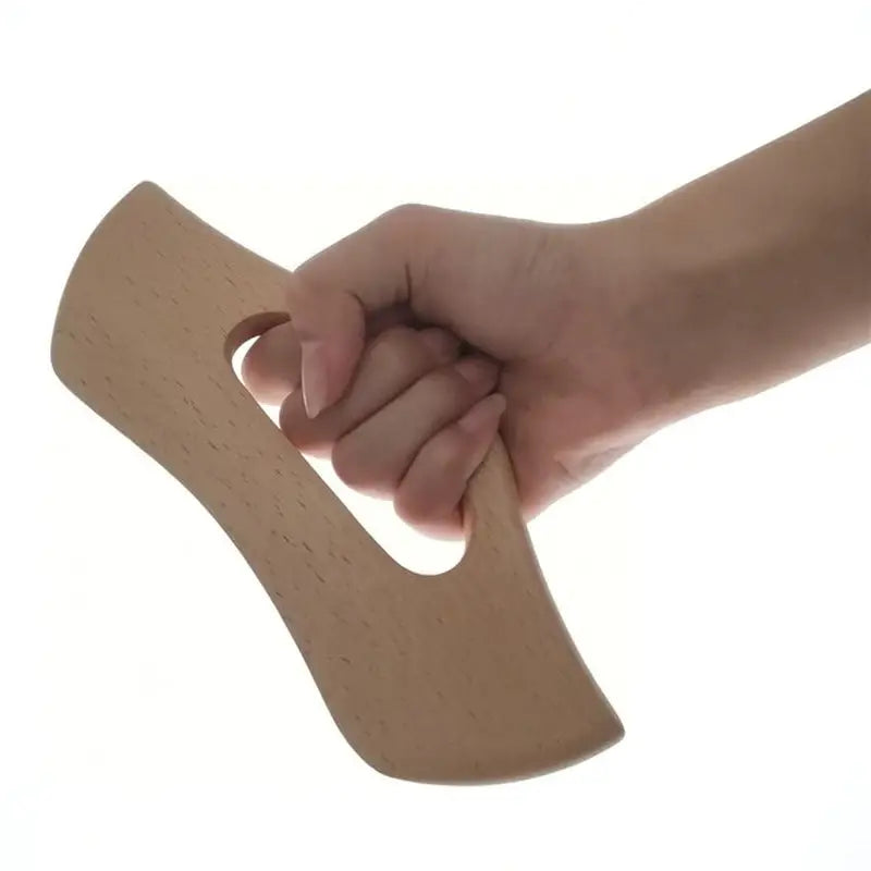 a hand holding a piece of wood