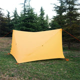 a tent with a yellow tent on the grass