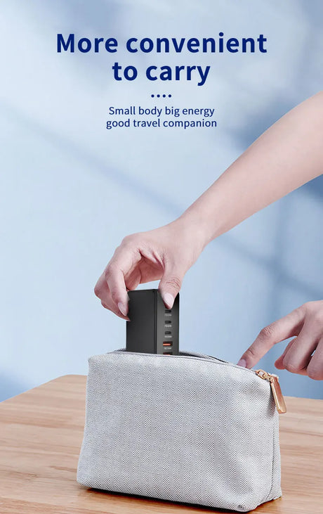 Compact black electronic device being placed into a light-colored travel pouch.