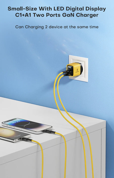 Compact yellow and black dual-port charger with LED display plugged into a wall outlet.