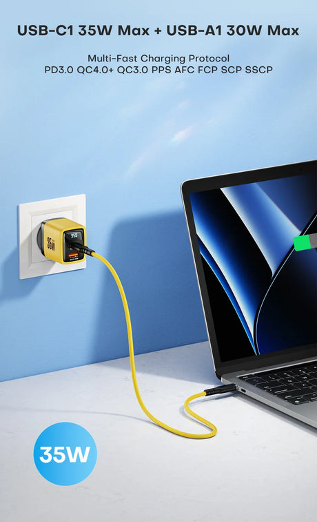 Compact yellow USB charger adapter plugged into a wall outlet with a cable connected to a laptop.