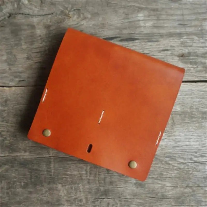 a small leather wallet on a wooden table