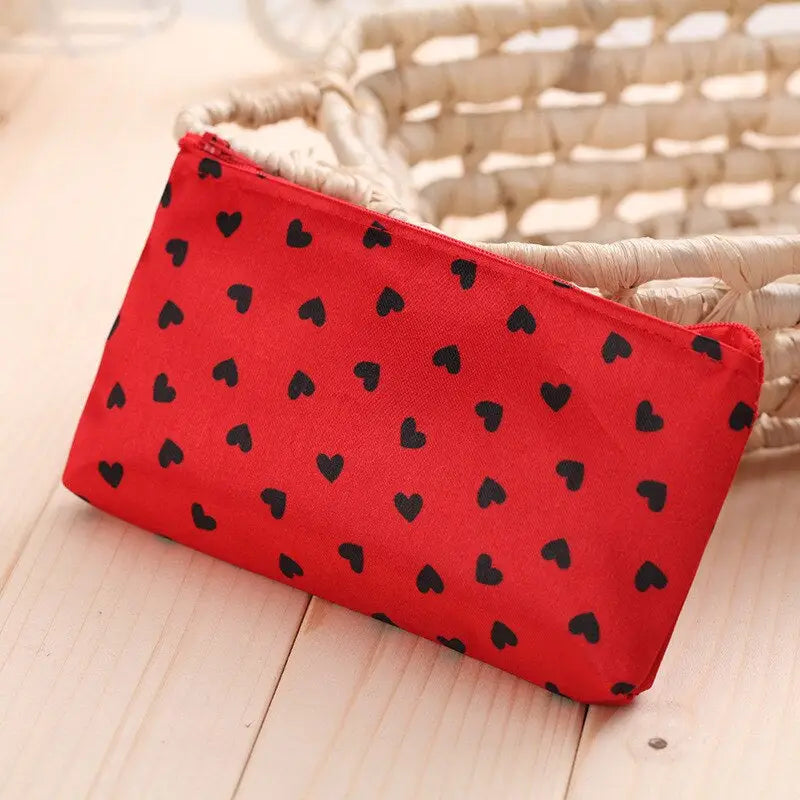 a red and black heart print pouch bag
