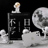 a small astronaut is sitting on the moon