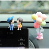 a couple sitting on top of a car dashboard