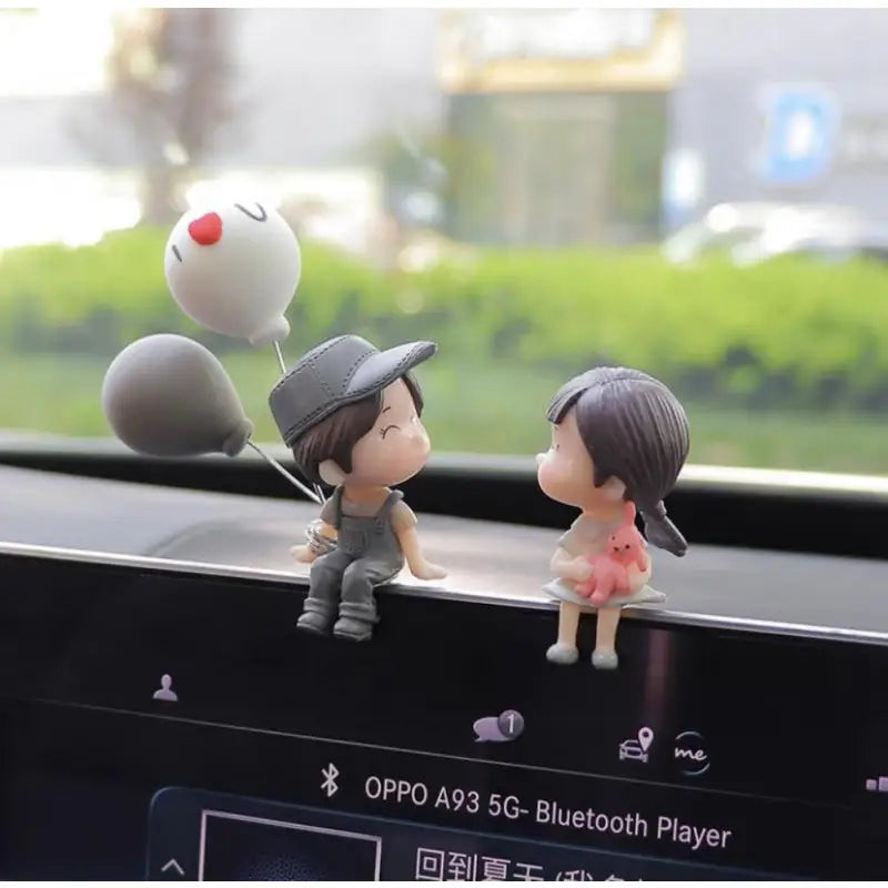 a couple of figuris sitting on a car dashboard