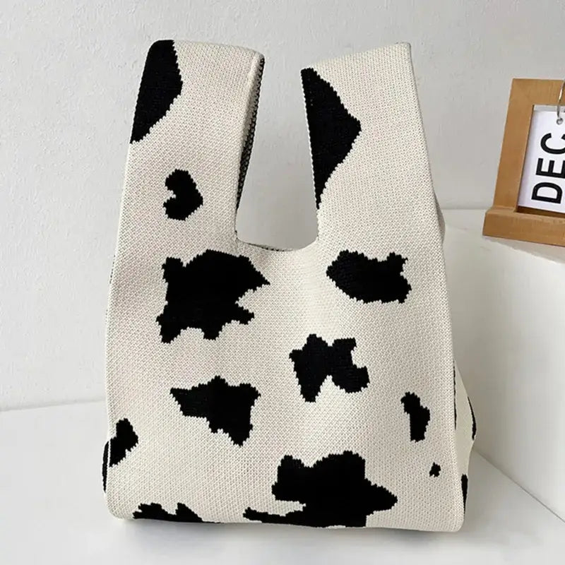 a cow print bag on a white table