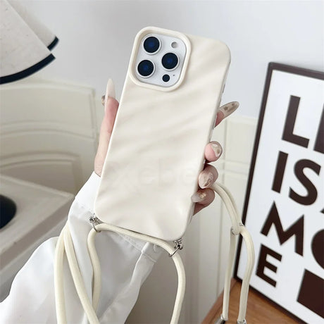 Cream-colored phone case with lanyard.