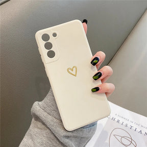 Cream-colored smartphone case with a gold heart design.