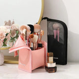 a pink makeup brush holder with a mirror and flowers