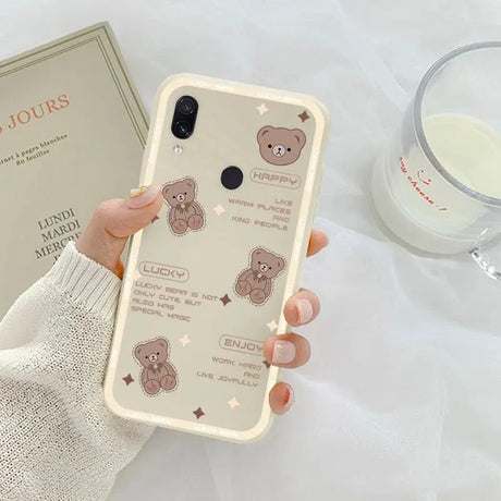 a woman holding a phone case with a bear design