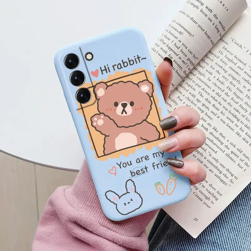a woman holding a phone case with a cartoon bear on it