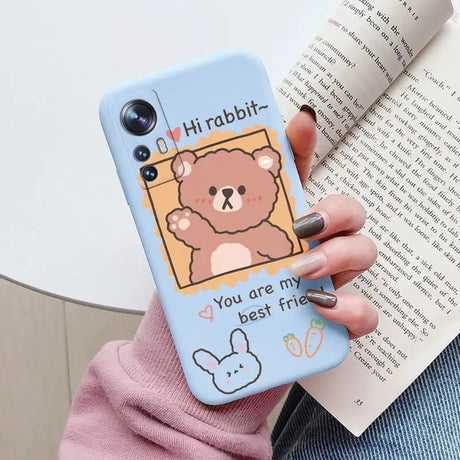 a woman holding a phone case with a bear on it