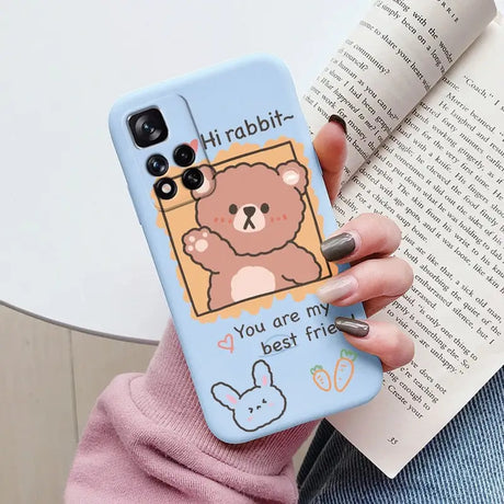 a woman holding a phone case with a cartoon bear