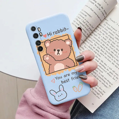 a woman holding a phone case with a bear on it