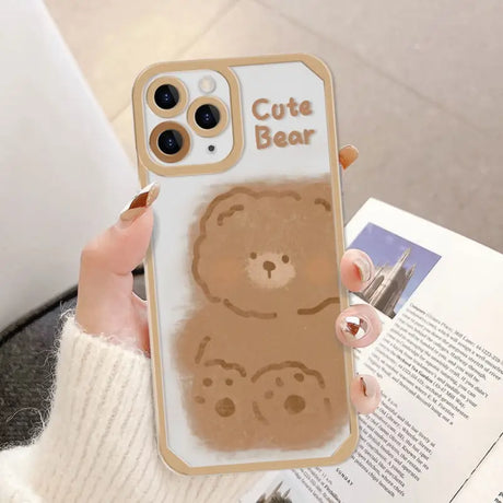 a woman holding a phone case with a bear on it