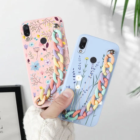 a woman holding a phone case with colorful flowers and birds