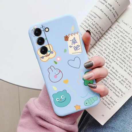 a woman holding a phone case with a pattern of animals and fish