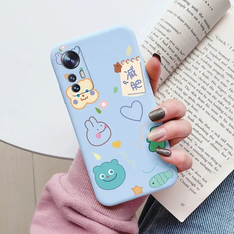 a woman holding a phone case with a pattern of animals and fish