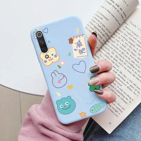 a woman holding a phone case with a pattern of animals and fish