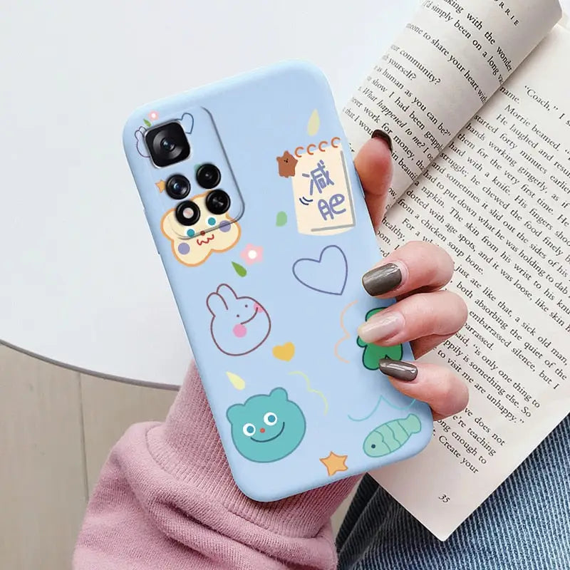 a woman holding a phone case with a pattern of animals